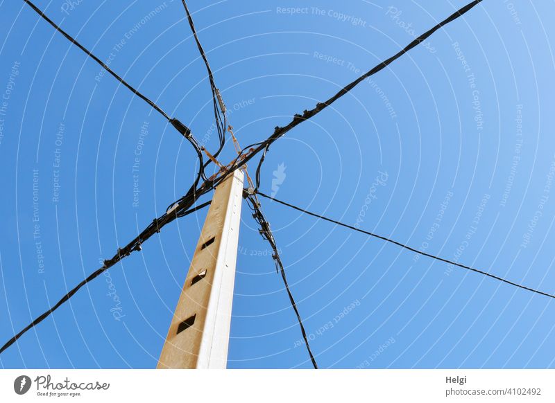 mediterrane Stromversorgung - Mast mit verschiedenen Stromkabeln vor blauem Himmel Strommast Kabel Leitung Stromleitungen schönes Wetter Froschperspektive