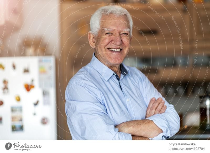Lächelnder älterer Mann in seinem Haus Menschen eine Person Senior reif Rentnerinnen in den Ruhestand getreten alt graues Haar Kaukasier Erwachsener Lifestyle