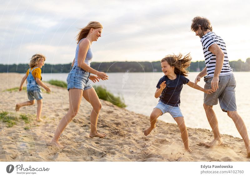 Junge Familie mit Spaß im Freien am Strand MEER See Feiertage Urlaub Natur Sommer Eltern Sohn Kinder Zusammensein Zusammengehörigkeitsgefühl Liebe Menschen