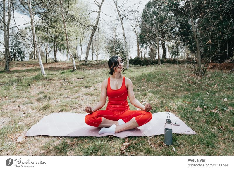 Junge Frau in Fitness-Kleidung tun Yoga-Übungen über eine Yoga-Matte im Park während eines sonnigen Tages Person Laptop Gesundheit außerhalb