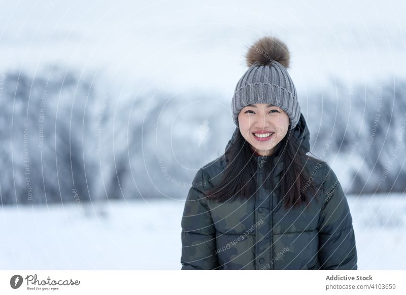 Fröhliche Frau in warmer Kleidung vor winterlicher Kulisse Auge Winter Freude Lächeln Charme sich[Akk] entspannen zufrieden Glück Schönheit charismatisch Natur