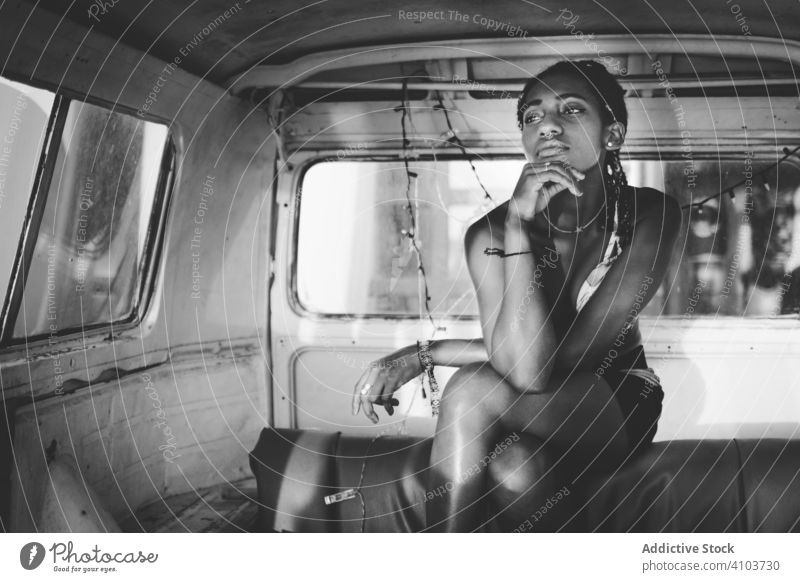 Nachdenkliche afroamerikanische Frau, die in einem alten Lieferwagen sitzt besinnlich träumen nachdenklich Denken sich[Akk] entspannen altehrwürdig sitzen retro