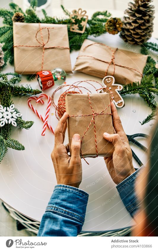 Person bereitet Weihnachtsgeschenke mit Seil und Weihnachtsschmuck vor Weihnachten Geschenk präsentieren Feiertag Kasten Papier Dekoration & Verzierung Bändchen