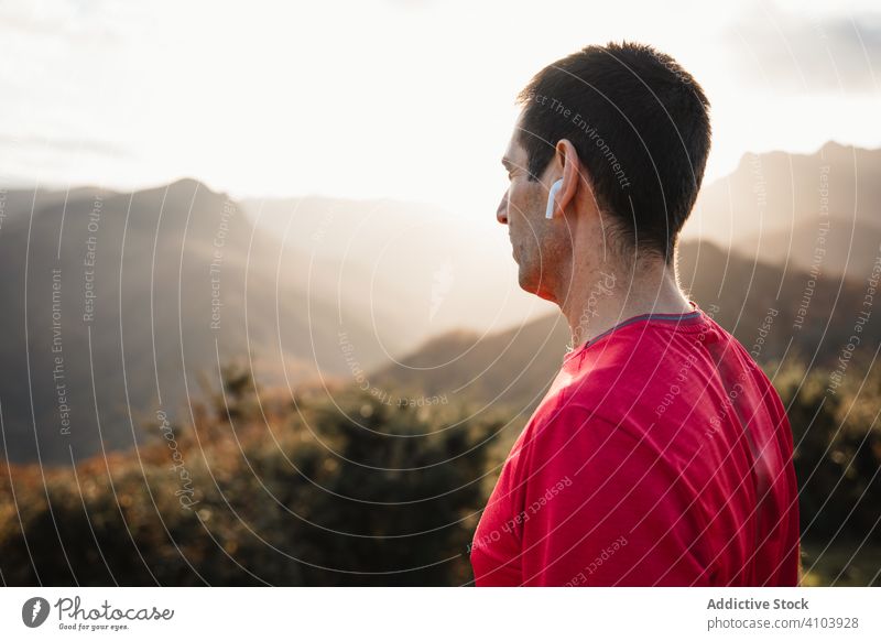 Männlicher Läufer, der sich ausruht und die Berglandschaft genießt Sportler ruhen Berge u. Gebirge Mann Freiheit sportlich Inspiration sich[Akk] entspannen