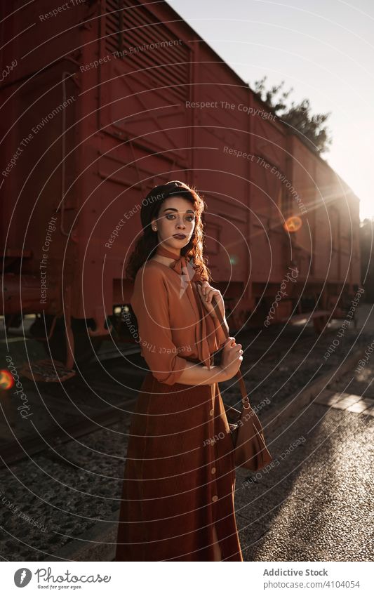 Frau in alter Kleidung steht auf einem Bahnhof und hält ein offenes Buch in der Hand altehrwürdig Station Eisenbahn Terrakotta Zug Beteiligung träumend völlig
