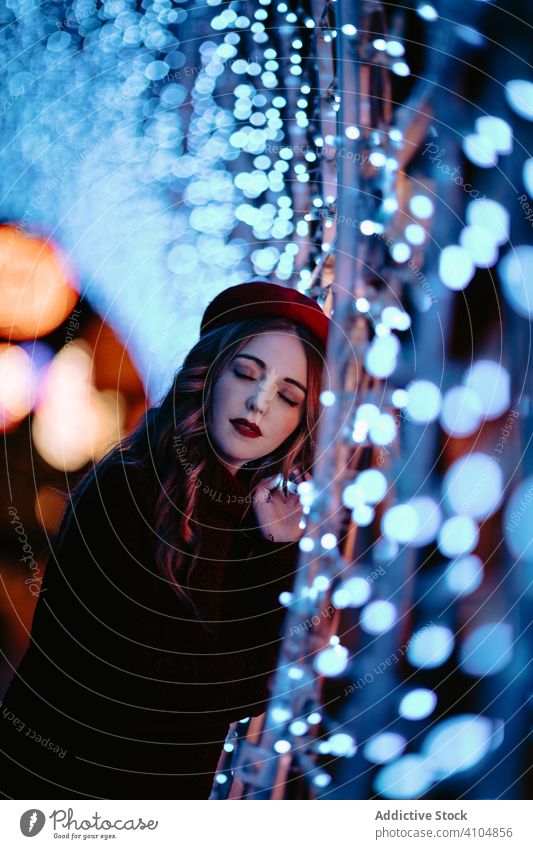 Charmante Dame mit Hut genießt Dekorationslichter in der Stadtstraße Frau Lichter Nacht Weihnachten erstaunt wow aufgeregt träumen Großstadt Straße lässig