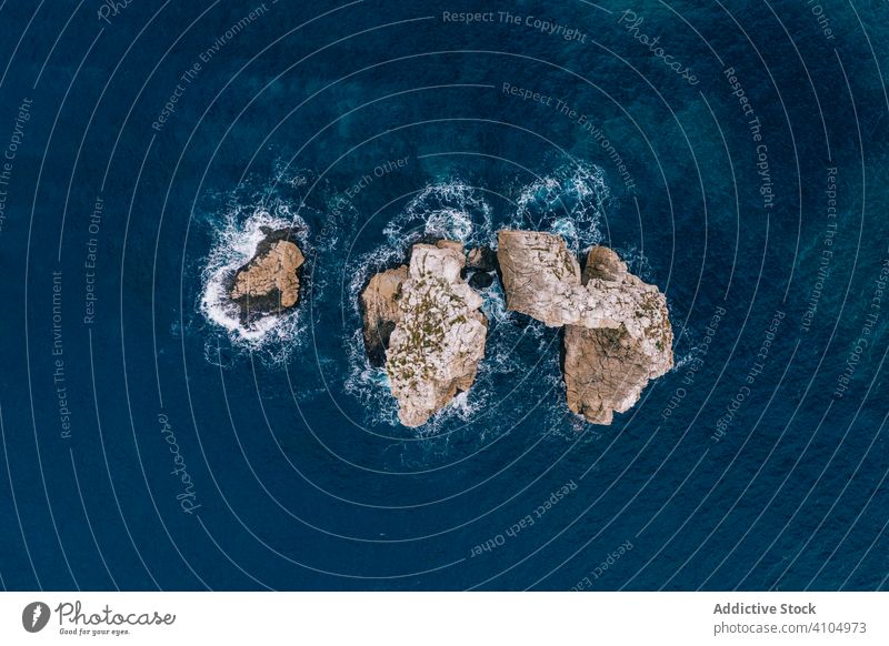 Steinige Insel, umgeben von dunkelblauem Wasser Gipfel Meer felsig türkis schaumig MEER tropisch Urlaub Natur reisen exotisch Paradies Tourismus pielagos
