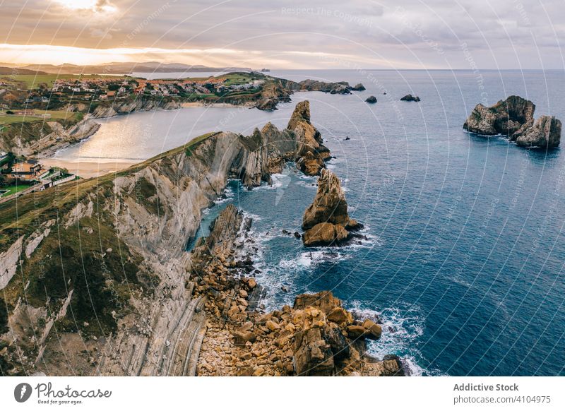 Steinerne Gipfel und Meeresufer und schäumende Wellen unter bewölktem Himmel MEER Landschaft Ufer Wasser Natur reisen malerisch wolkig Kantabrien Santander