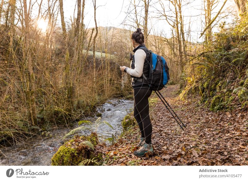 Anonyme Wanderin mit Rucksack auf Erkundungstour im Wald Wohnmobil Fluss Trekking Wasser Pflanze grün Sonnenlicht wandern Frau Sportkleidung Lifestyle Wanderung