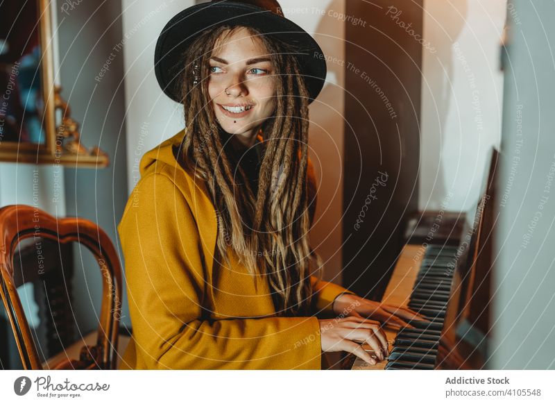 Hipster tausendjährige Frau spielt Klavier spielen Rastalocken Musik stylisch sitzen fokussiert konzentriert praktizieren Musiker Instrument Kunst Pianist