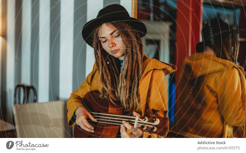 Hipster Millennial Frau spielt Ukulele Gitarre spielen Musik stylisch tausendjährig Raum Antiquität altehrwürdig hawaiianisch stehen fokussiert konzentriert