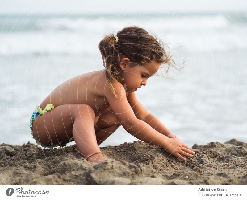 Kleines Mädchen baut Sandburg am Strand spielen MEER Burg oder Schloss Haufen sitzen Lenden Kind Sommer Urlaub Saison Meer Wasser Lifestyle ruhen
