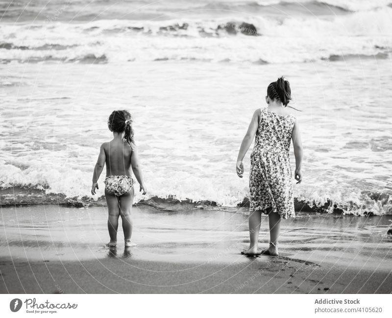 Anonyme Schwestern am wogenden Meer MEER Strand winken Wasser Sand nass Familie Zusammensein Sommer Geschwisterkind Mädchen Kind Natur Lifestyle ruhen