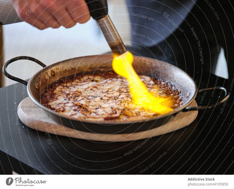 Prozess der Zubereitung eines Gerichts der Haute Cuisine im Restaurant Küchenchef Essen zubereiten Speise Gasbrenner Flamme Pfanne Reis Octopus Platte Teller