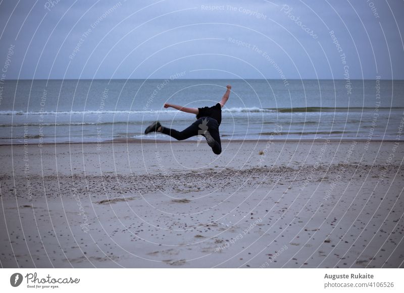 Mann macht Akrobatik am Strand. Launisches Wetter und Regen launischer Himmel Stimmung launisches Wetter stimmungsvolle Atmosphäre Naturhintergrund
