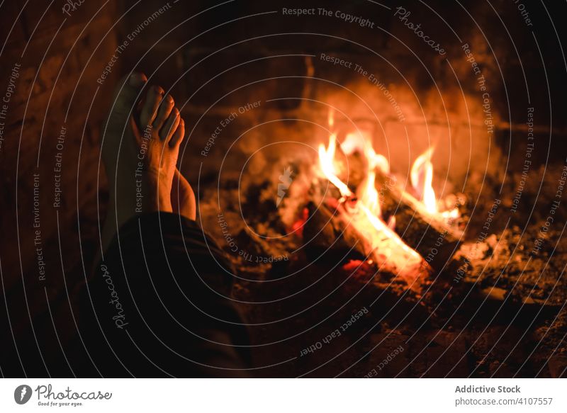 Silhouette einer Person, die sich im Dunkeln die Füße am Kamin wärmt Feuerstelle warm Haus gemütlich Wochenende ländlich Fuß lebend Freudenfeuer kuscheln dunkel