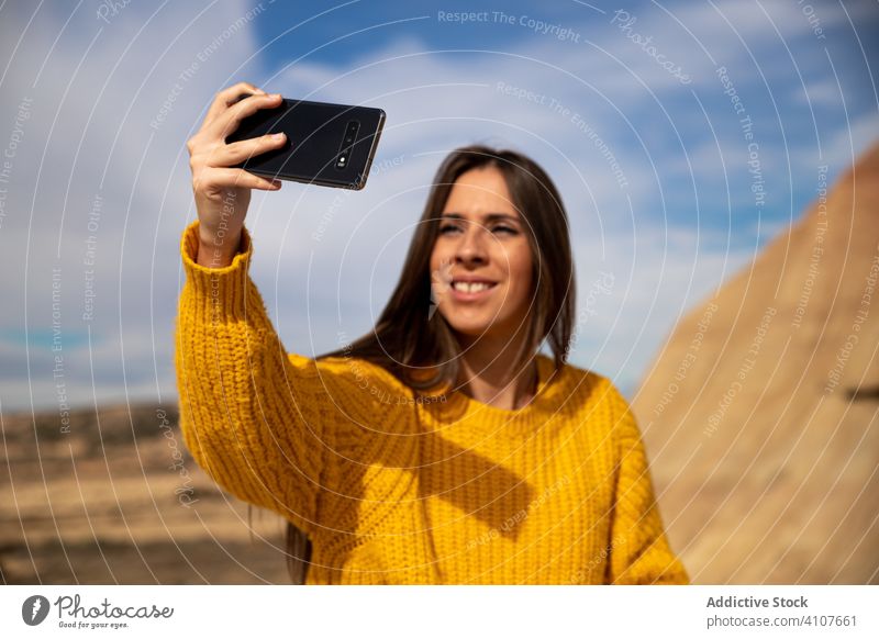 Zufriedene Frau nimmt Selfie auf Smartphone mit großem Felsen im Urlaub Schießen benutzend Handy Klippe Berge u. Gebirge Stein Blauer Himmel Natur Lächeln