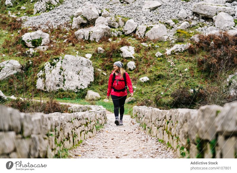 Frau, die auf einem Weg mit Steinzaun zwischen hohen Felsen läuft Tourist Gipfel Berge u. Gebirge Hügel reisen Natur Trekking Landschaft Tourismus Abenteuer