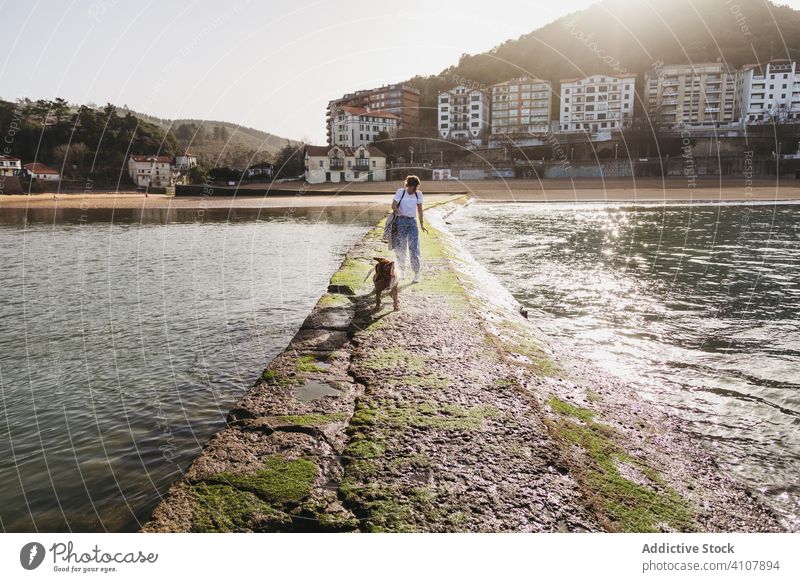 Frau mit Hund beim Spaziergang auf dem Steinpier Pier Gebäude Wasser MEER Zusammensein Haustier Küste Tier Lifestyle jung lässig Freundschaft Spanien lekeitio