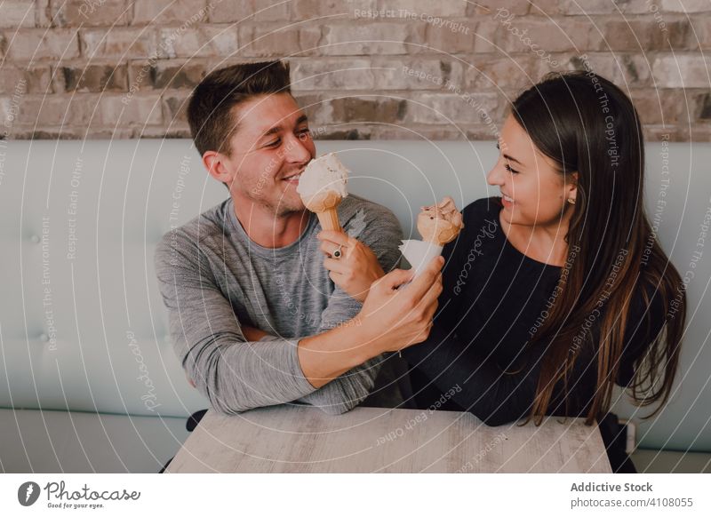 Glückliches Paar isst Eiswaffeln bei einer Verabredung in einem Cafe Termin & Datum Speiseeis Flirten Café Dessert Liebe Freude Futter heiter Lächeln