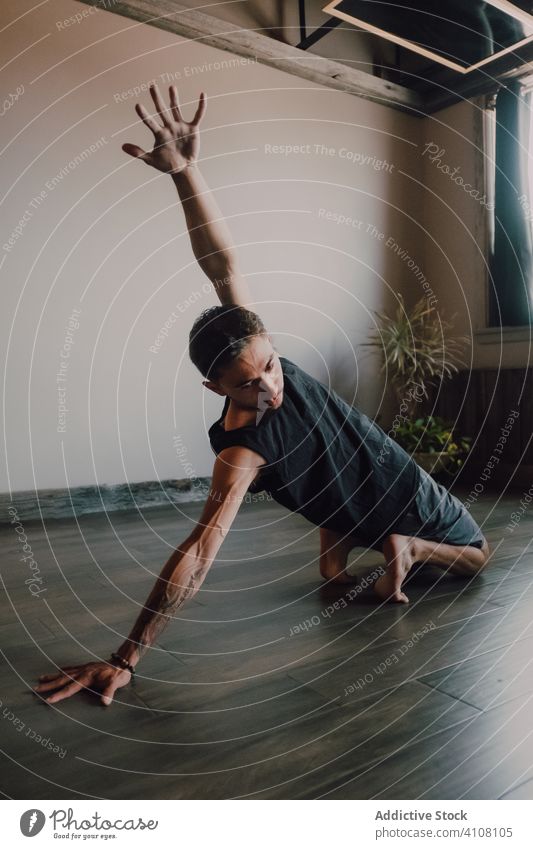Erwachsener Mann trainiert allein in modernem Studio Athlet Übung Training Dehnung beweglich Tanzen Yoga üben akrobatisch Wellness Gesundheit Aufwärmen schlank