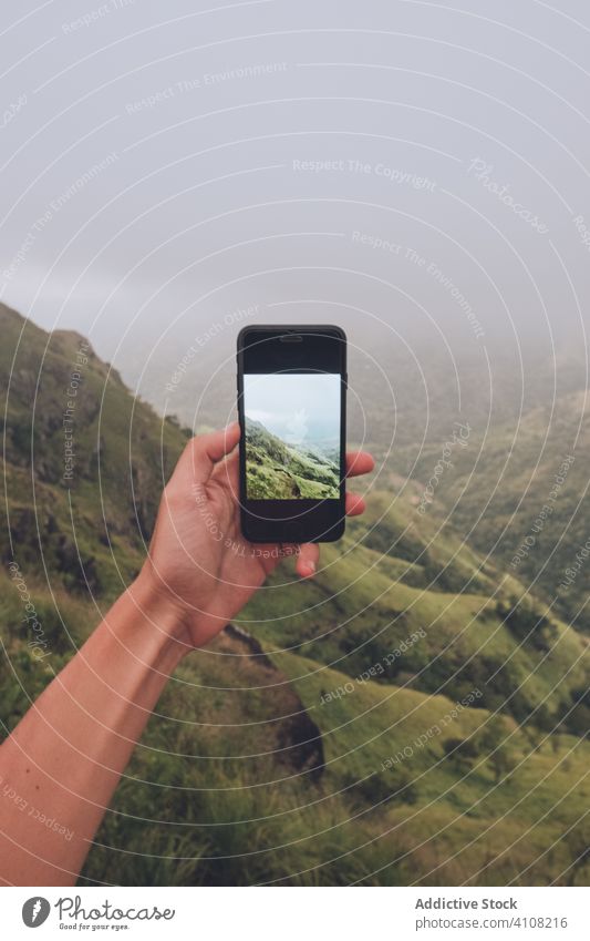 Anonymer Tourist, der die Landschaft mit seinem Smartphone fotografiert Reisender Tourismus fotografieren Nebel exotisch tropisch grün Bild benutzend Mobile