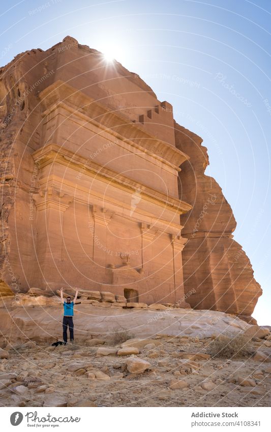 Männlicher Tourist bei der Besichtigung von Sehenswürdigkeiten in der Wüste genießen Sightseeing Mann wüst Grabmal behauen Klippe Reisender Freiheit männlich