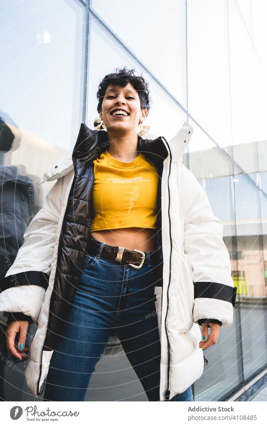 Trendige junge Frau auf einer Straße in der Stadt Stil Teenager farbenfroh heiter cool warme Kleidung Lächeln genießen Großstadt Freude modern lässig positiv