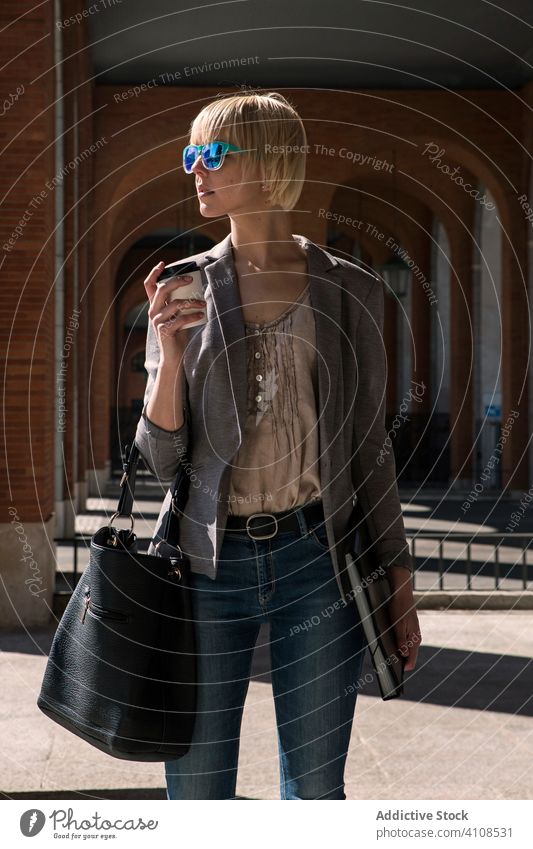 Geschäftsfrau mit Kaffeetasse auf der Straße stylisch jung Frau Mappe professionell Person schön attraktiv Imbissbude Tasse Papier Sonnenbrille Handtasche