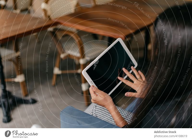 Frau benutzt Tablet in einem Café Tablette benutzend berühren lässig jung Browsen online Internet modern Apparatur Gerät Lifestyle Surfen Kommunizieren