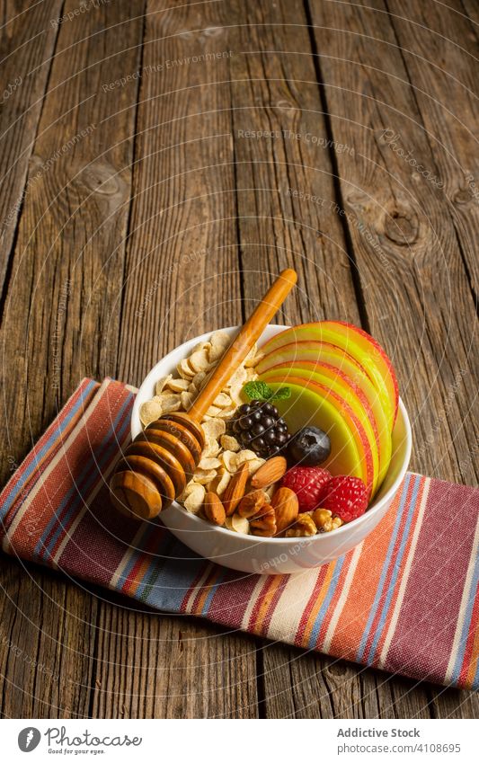 Schale mit Nüssen, Obst und Beeren mit Honigdipper Supernahrung Frühstück Gesundheit Nut Ernährung frisch Abblendschalter Apfel Müsli Diät organisch Mahlzeit