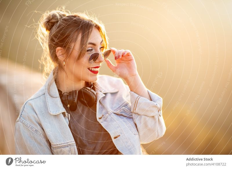 Stilvolle Frau in lässiger Kleidung erfreut sich am Anblick Lächeln genießen Sonne trendy Lifestyle Harmonie Mode ruhen sich[Akk] entspannen Outfit Wochenende