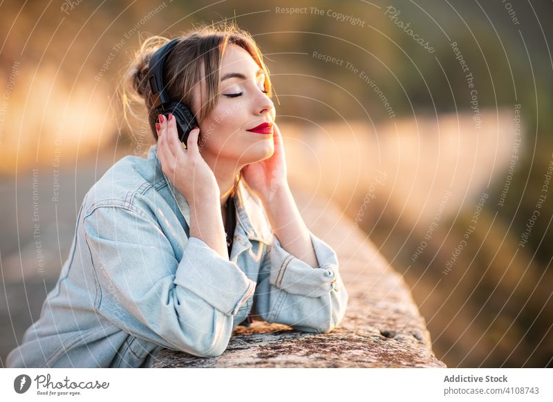 Frau genießt Musik mit Kopfhörern zuhören genießen Lächeln geschlossene Augen lässig Natur Stil Freude Lifestyle ruhen modern Klang Gesang Audio jung Dame