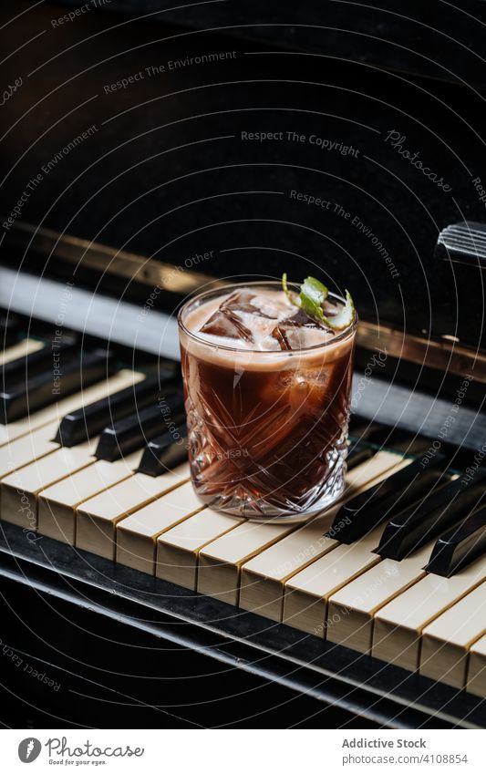 Cocktailglas mit Eis, das auf einer Klaviertaste ruht trinken Getränk Hand Pub Restaurant Bar Minze schäumen frisch klassisch sich[Akk] entspannen Kunst lecker