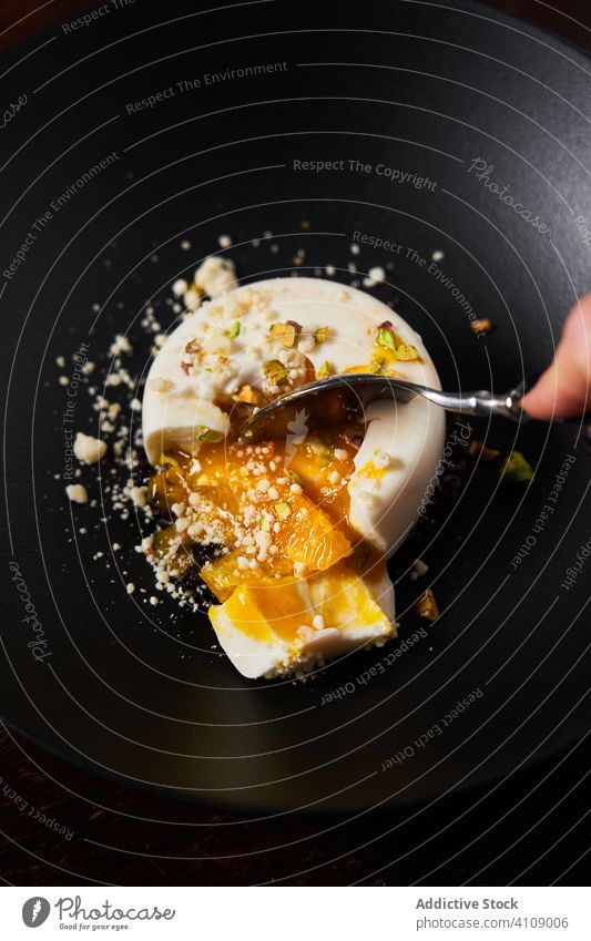 Anonyme Frau isst stilvolles Dessert mit Löffel Restaurant Konditorei Götterspeise verglast Arme Hand benutzend Schalen & Schüsseln Teller Nut süß Gesundheit