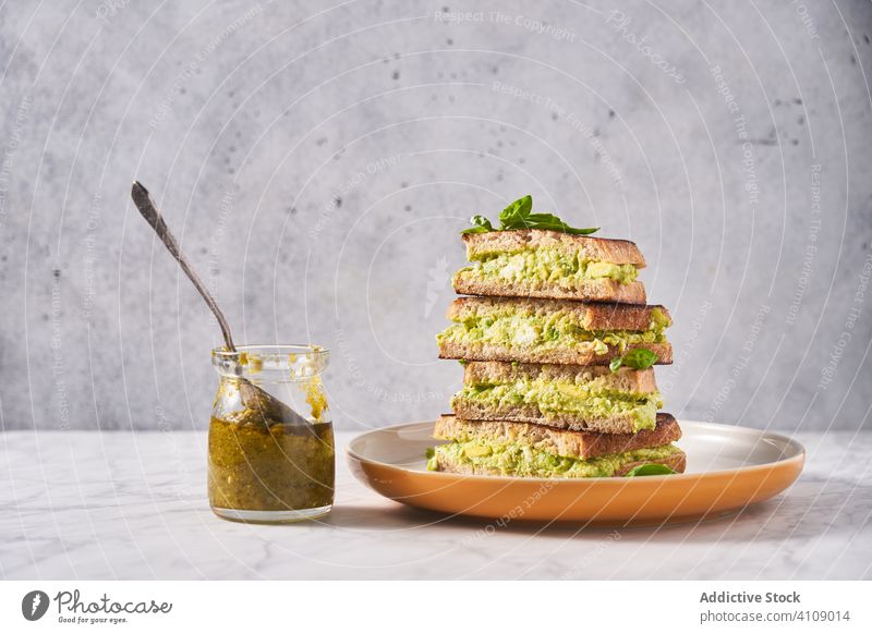 Gesunde Sandwiches mit Guacamole und Minze Belegtes Brot Speise Teller avicado Pesto Saucen Glas Tisch Stapel Löffel Gesundheit Kraut Smoothie Ernährung
