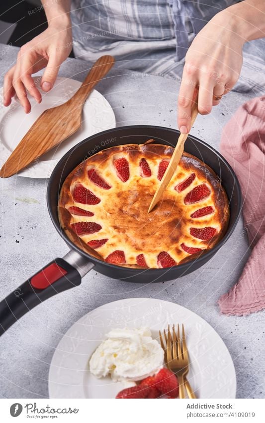 Unbekannte Frau schneidet Kuchen mit Messer Pasteten gebacken Dessert Schneiden Koch Servieren dekorierend Erdbeeren Sauerrahm Küchenchef selbstgemacht Haushalt