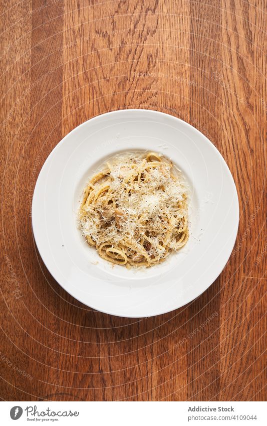 Portion Nudeln mit Parmesan Spätzle Spaghetti traditionell kulinarisch Käse Speise Lebensmittel Teller Restaurant Mahlzeit hölzern Tisch klassisch Italienisch