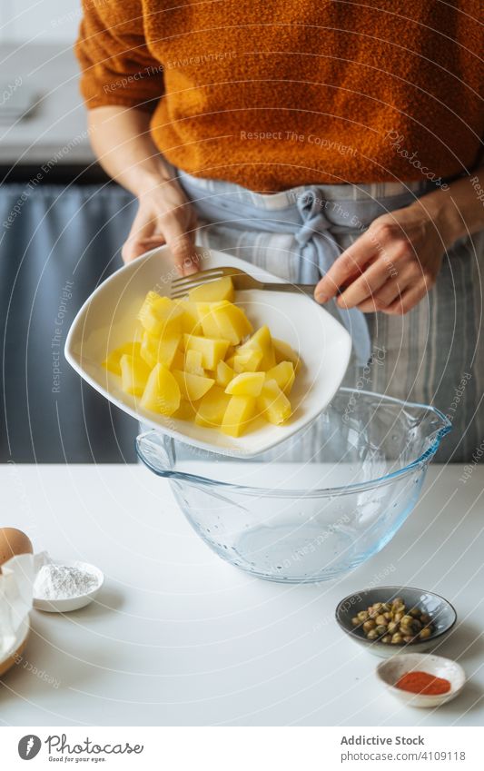 Frau legt gekochte, geschnittene Kartoffeln in eine Schüssel Lebensmittel Essen zubereiten Rezept Gemüse Bestandteil Küche Mahlzeit Schalen & Schüsseln