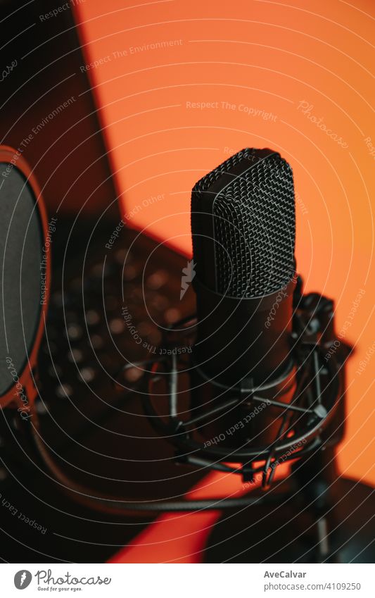 Close up mock up von einem Streaming-Mikrofon mit einem Laptop über einem orangefarbenen Hintergrund mit Kopie Raum, minimales Konzept, Technologie-Streaming