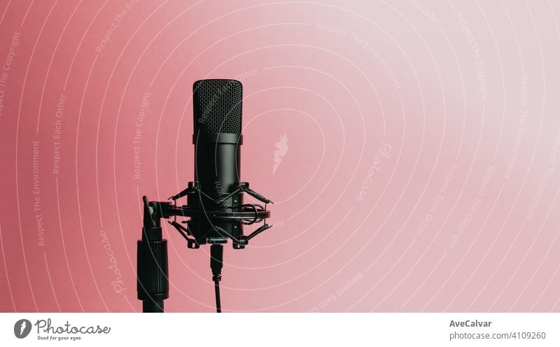 Minimalistisches Bild eines Streaming-Mikrofons über einem pastellrosa Hintergrund mit Kopierraum, minimales Konzept, Technologie-Streaming Attrappe sehr wenige