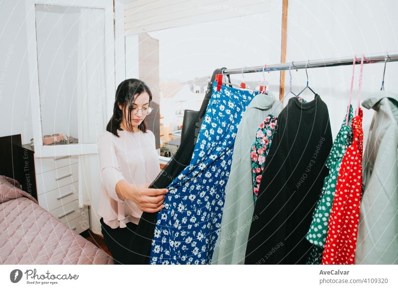 Junge arabische Frau überprüft seine Kleidung zu Hause während einer super hellen Tag, Einzelhandel und Wiederverkauf Konzept jung Verkauf Bekleidung Käufer