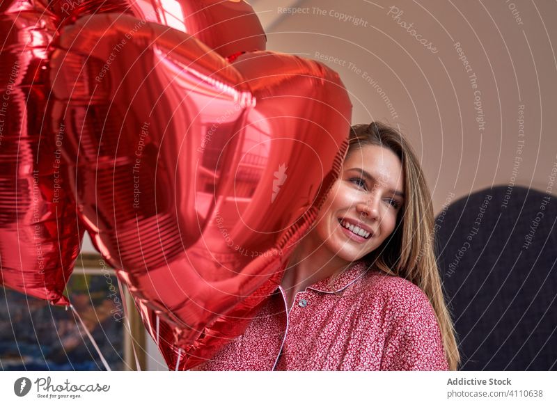 Glückliche erwachsene Frau mit Geschenken zum Valentinstag Valentinsgruß Luftballon romantisch Herz aufgeregt Liebe feiern Veranstaltung Feiertag präsentieren