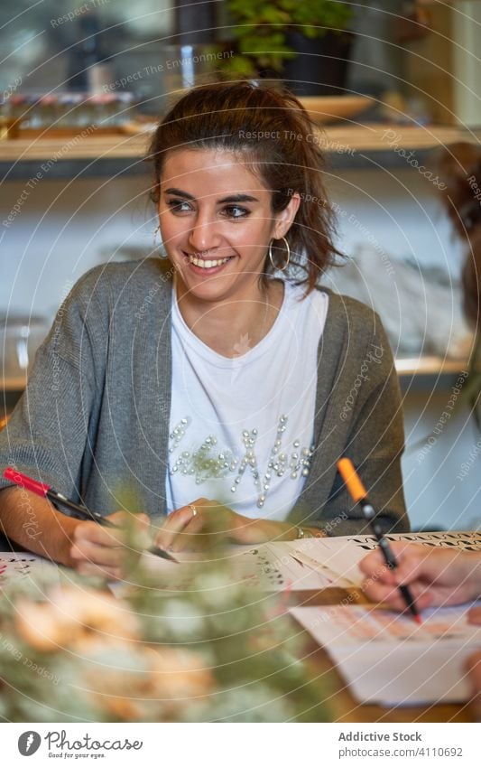 Künstlerin zeichnet mit Bleistift im Kunstatelier Frau Beschriftung Handschrift zeichnen Konzentration kreativ Fokus Lifestyle lernen Job sitzen Skizze
