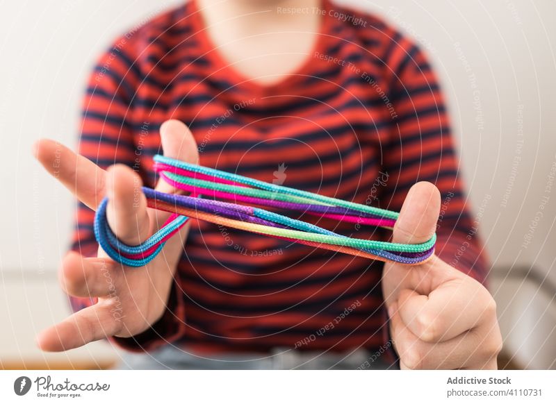 Kluges Kind benutzt Gummibänder zum Spielen Band kreativ farbenfroh lernen Erziehung spielen elastisch wenig Handfläche verdrehen lässig heimwärts Spaß Feiertag