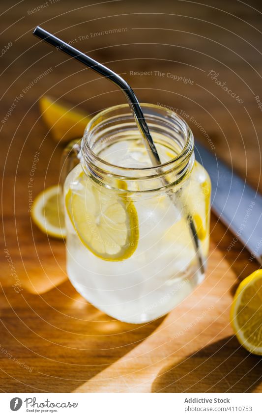 Glasgefäß mit Eis und Strohhalm auf dem Tisch Zitrone metallisch wiederverwendbar Kannen Scheibe hölzern umweltfreundlich ablehnen Küche frisch Getränk kalt