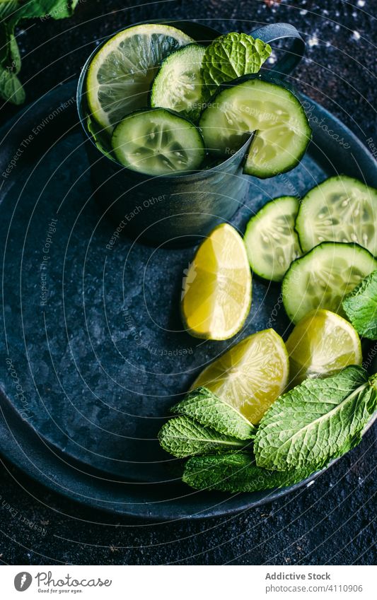 Gurken-Detox-Getränk mit Minze und Limette Salatgurke Entzug trinken Bestandteil Tisch Kalk Zitrone kalt Becher Tablett dunkel frisch Gesundheit natürlich