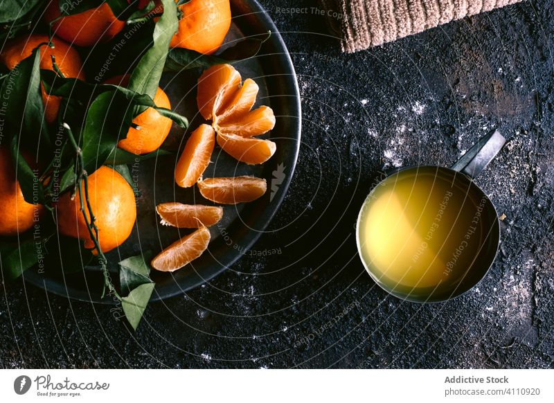 Frischer Saft und Mandarinen auf schwarzem Tisch frisch reif Frucht rau Serviette Teller Becher Lebensmittel organisch Zitrusfrüchte Gesundheit natürlich lecker