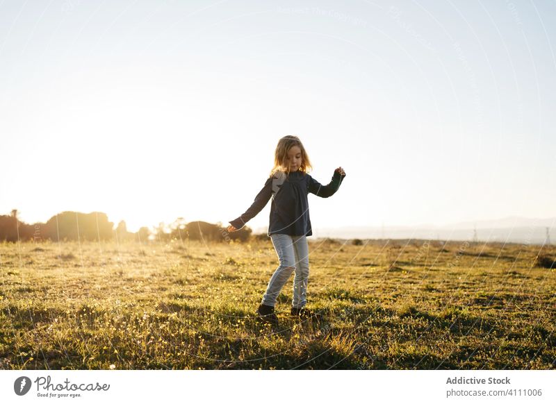 Kleines Mädchen hat Spaß im Feld Kind Glück Natur genießen Spaß haben spielen Tanzen Sonnenuntergang Abend Wiese Landschaft Freiheit Gras Sommer Freude