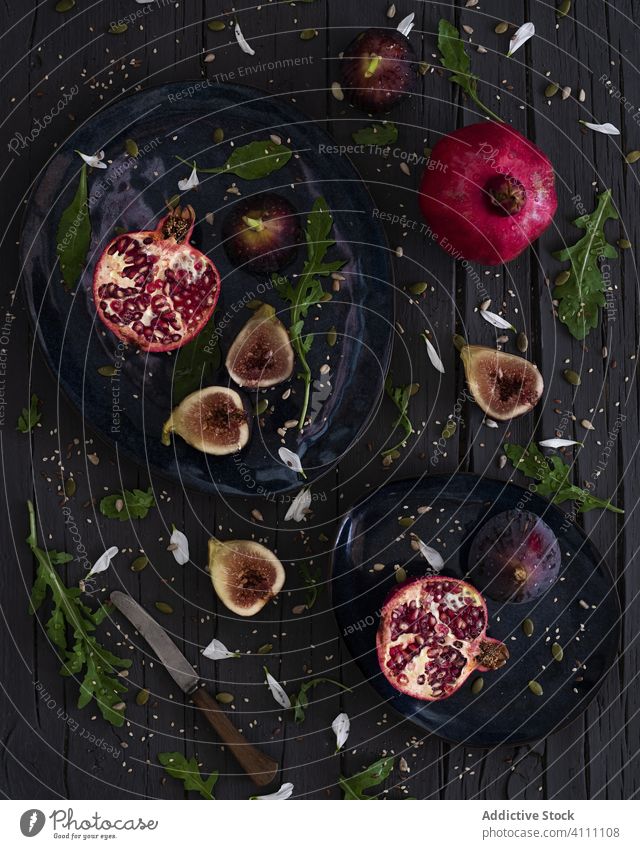 Feigen und Granatäpfel mit Kräutern Frucht Teller frisch Kraut Tisch Messer Rucola Granatapfel organisch reif Lebensmittel süß geschmackvoll lecker Vegetarier